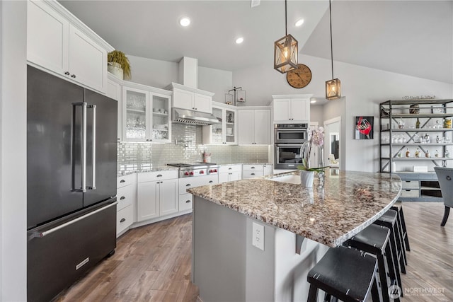 167 N Shore Dr, Orondo, WA 98843 - kitchen featuring appliances with stainless steel finishes, under cabinet range hood, white cabinets, backsplash, and glass insert cabinets