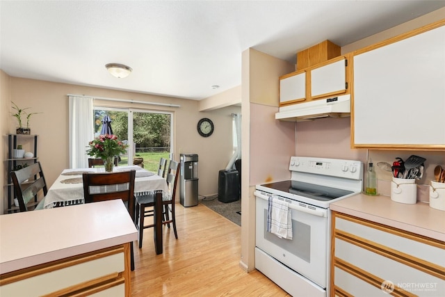 643 School St SE, Lacey, WA 98503 - kitchen with white range with electric stovetop, under cabinet range hood, light countertops, light wood-style floors, and white cabinetry