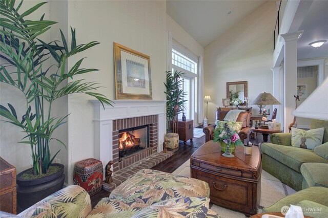 30 Chauncey Ln W, Pacific Beach, WA 98571 - living room featuring high vaulted ceiling, wood finished floors, and a brick fireplace