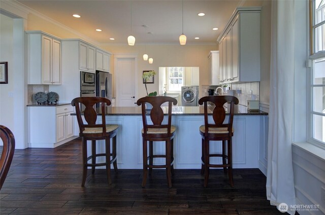 30 Chauncey Ln W, Pacific Beach, WA 98571 - kitchen featuring appliances with stainless steel finishes, washer and clothes dryer, dark countertops, backsplash, and recessed lighting