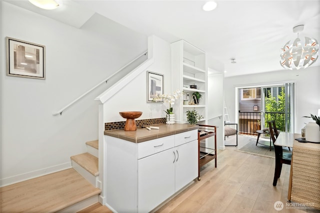 4795 35th Ave S Unit B, Seattle, WA 98118 - bar featuring stairs, light wood finished floors, a chandelier, and pendant lighting