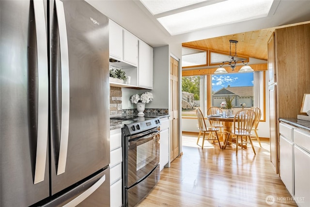 8380 Grouse Crescent Dr, Blaine, WA 98230 - kitchen with freestanding refrigerator, black / electric stove, a chandelier, light wood-style flooring, and white cabinets
