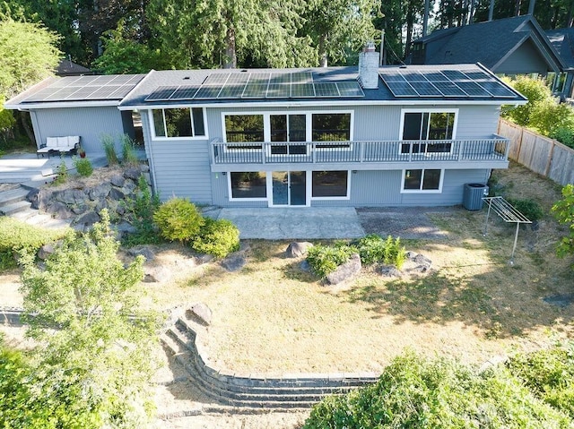 21424 Calhoun Rd, Monroe, WA 98272 - back of property featuring a chimney, solar panels, and a patio