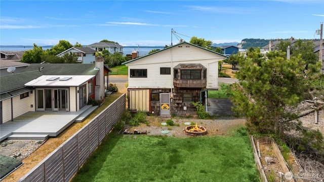 2403 Sunlight Beach Rd, Clinton, WA 98236 - back of property featuring a wooden deck, an outdoor fire pit, a residential view, and a fenced backyard