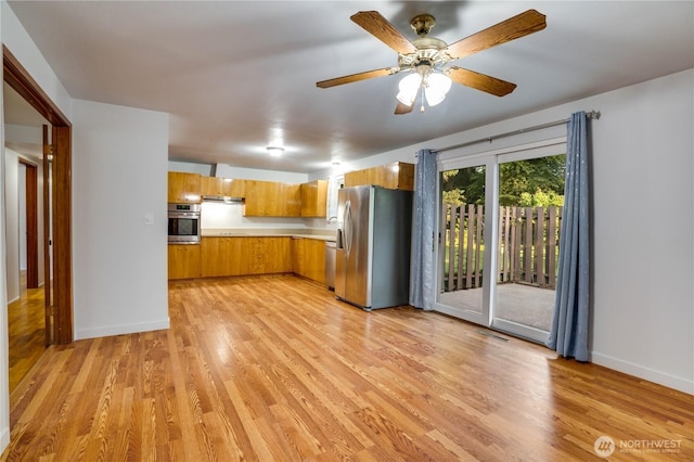 1202 Brookdale Rd E, Tacoma, WA 98445 - kitchen featuring appliances with stainless steel finishes, brown cabinets, light countertops, and light wood-style flooring