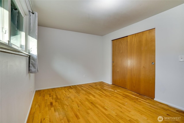 1202 Brookdale Rd E, Tacoma, WA 98445 - unfurnished bedroom with wood finished floors, baseboards, and a closet