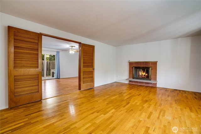 1202 Brookdale Rd E, Tacoma, WA 98445 - unfurnished living room with light wood-style floors and a brick fireplace