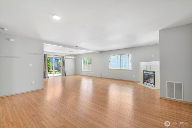 3929 152nd Pl SE, Bothell, WA 98012 - unfurnished living room featuring a tiled fireplace and light wood-style floors