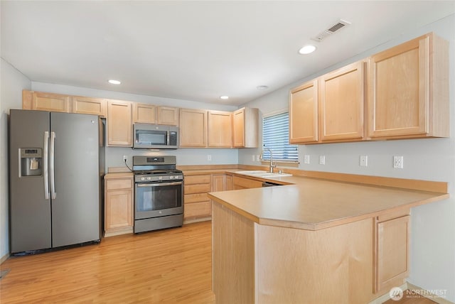 3929 152nd Pl SE, Bothell, WA 98012 - kitchen featuring light brown cabinets, stainless steel appliances, light wood-style flooring, a peninsula, and light countertops