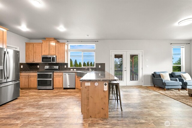 3664 N Red River Rd, Ferndale, WA 98248 - kitchen featuring appliances with stainless steel finishes, a peninsula, a breakfast bar, light wood-style flooring, and open floor plan
