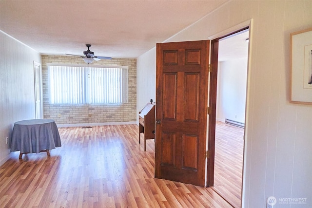 4708 63rd Ave W, Tacoma, WA 98466 - hall with light wood-type flooring, a baseboard radiator, and brick wall