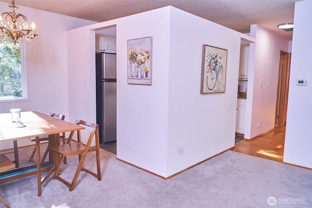 4708 63rd Ave W, Tacoma, WA 98466 - dining space featuring light colored carpet, a chandelier, baseboards, and a textured ceiling