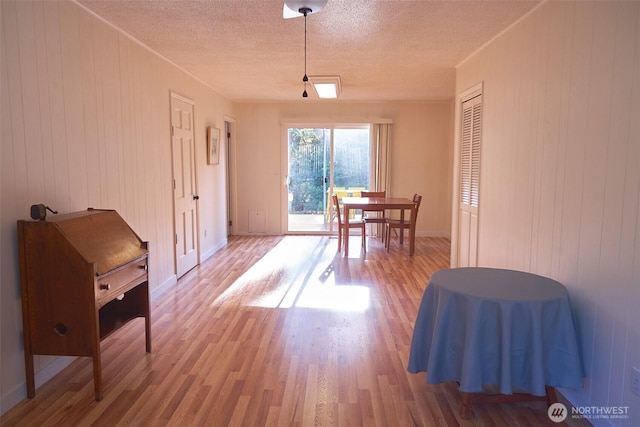 4708 63rd Ave W, Tacoma, WA 98466 - dining area featuring light wood-style flooring, a textured ceiling, wooden walls, and baseboards