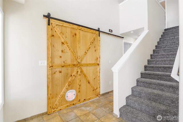 2352 W Covey Dr, Othello, WA 99344 - stairway featuring a barn door, baseboards, and stone finish floors