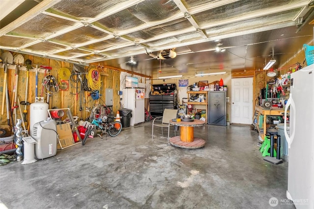 2352 W Covey Dr, Othello, WA 99344 - garage featuring freestanding refrigerator, a workshop area, and a garage door opener