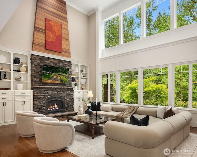 26507 SE Old Black Nugget Rd, Issaquah, WA 98029 - living room featuring a towering ceiling, hardwood / wood-style floors, a stone fireplace, and crown molding