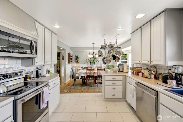 10825 4th Ave W, Everett, WA 98204 - kitchen with appliances with stainless steel finishes, decorative backsplash, light countertops, a peninsula, and recessed lighting