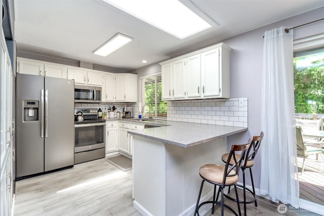 23310 133rd Ct SE, Kent, WA 98042 - kitchen with stainless steel appliances, a peninsula, white cabinets, and decorative backsplash
