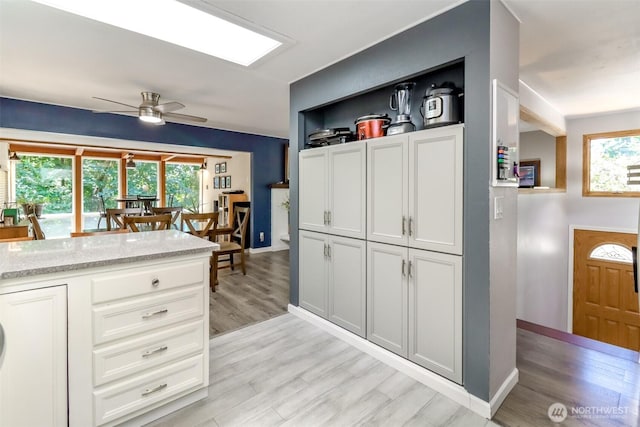 23310 133rd Ct SE, Kent, WA 98042 - kitchen featuring light wood finished floors, plenty of natural light, ceiling fan, and white cabinetry