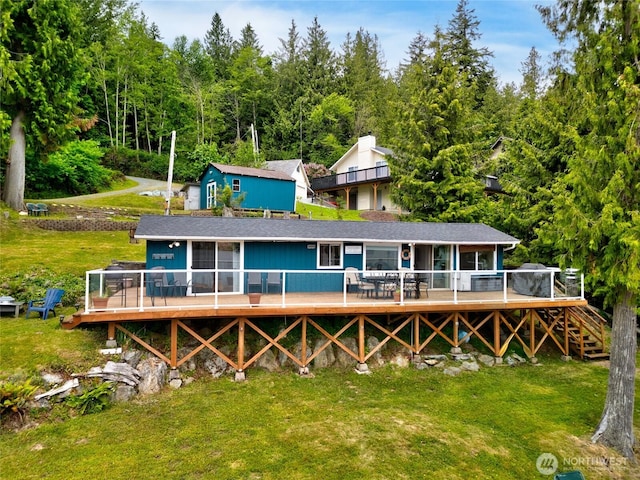 18933 W Big Lake Blvd, Mount Vernon, WA 98274 - back of property featuring a wooden deck, a lawn, and a forest view