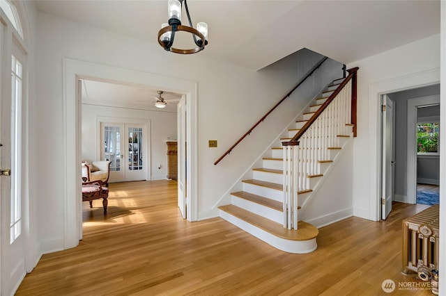 4918 S 3rd Ave, Everett, WA 98203 - staircase featuring wood finished floors, a chandelier, french doors, and ceiling fan