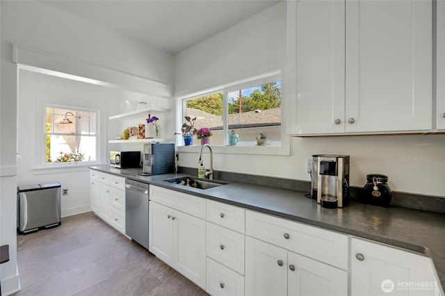 4918 S 3rd Ave, Everett, WA 98203 - kitchen with dishwasher, dark countertops, plenty of natural light, and white cabinetry