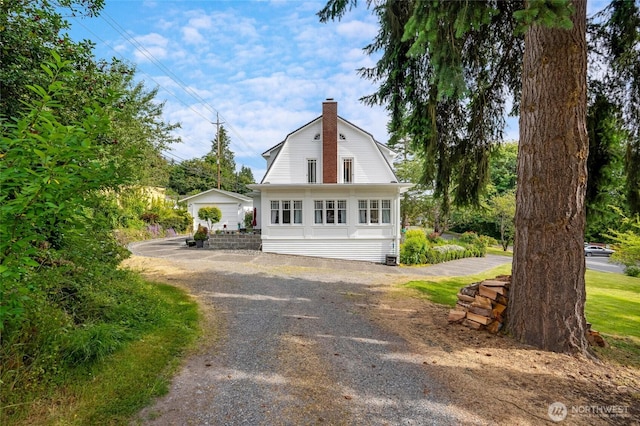 4918 S 3rd Ave, Everett, WA 98203 - view of front facade with a gambrel roof, a chimney, and dirt driveway