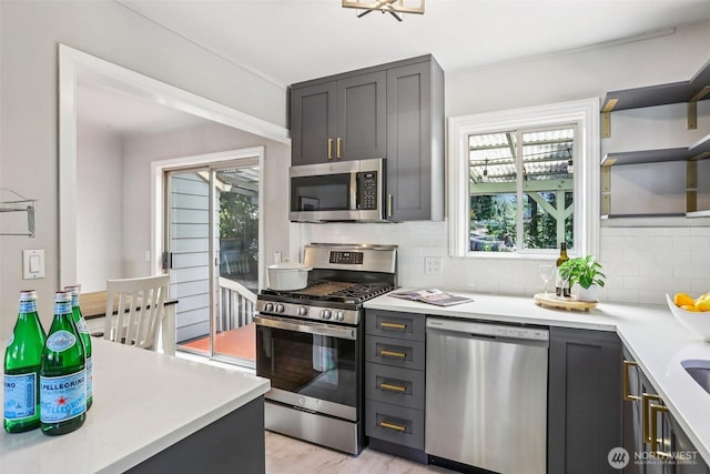 1535 NE 107th St, Seattle, WA 98125 - kitchen with stainless steel appliances, backsplash, and light countertops