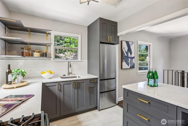 1535 NE 107th St, Seattle, WA 98125 - kitchen with decorative backsplash, healthy amount of natural light, freestanding refrigerator, and light stone counters