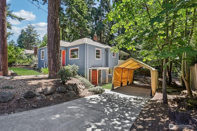 1535 NE 107th St, Seattle, WA 98125 - view of front facade featuring a carport, a chimney, and driveway