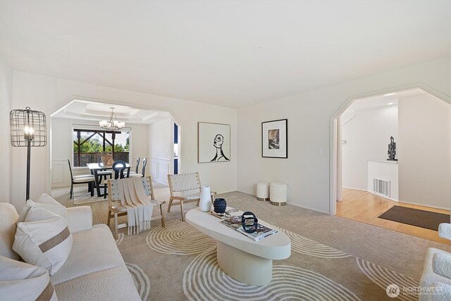 7109 SE 135th Pl, Newcastle, WA 98059 - carpeted living area featuring arched walkways and a chandelier