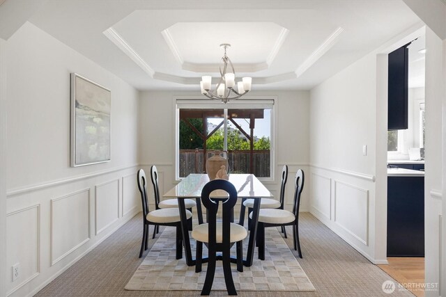 7109 SE 135th Pl, Newcastle, WA 98059 - dining space with a decorative wall, a chandelier, a raised ceiling, wainscoting, and light carpet