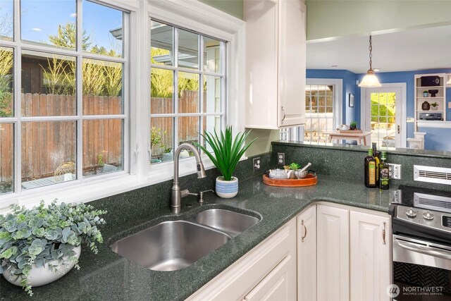 8816 Fauntleroy Way SW, Seattle, WA 98136 - kitchen featuring white cabinetry, hanging light fixtures, wall oven, and dark stone countertops
