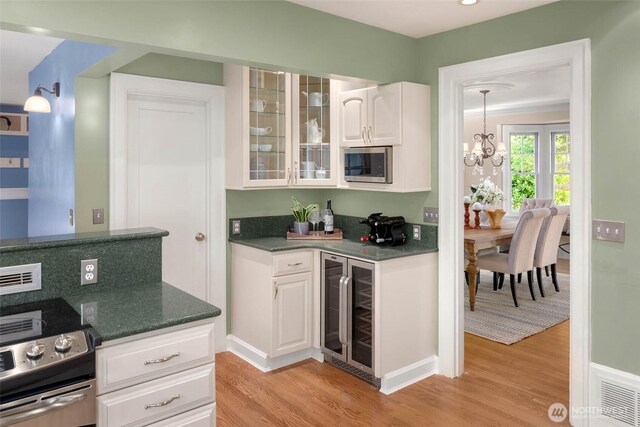 8816 Fauntleroy Way SW, Seattle, WA 98136 - indoor bar with wine cooler, stainless steel appliances, light wood finished floors, and a chandelier