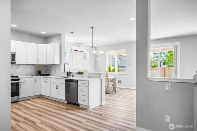 3410 102nd Ave NE, Lake Stevens, WA 98258 - kitchen featuring stainless steel appliances, a sink, a peninsula, light wood finished floors, and recessed lighting