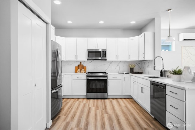 3410 102nd Ave NE, Lake Stevens, WA 98258 - kitchen featuring appliances with stainless steel finishes, a sink, a wall unit AC, tasteful backsplash, and light wood finished floors