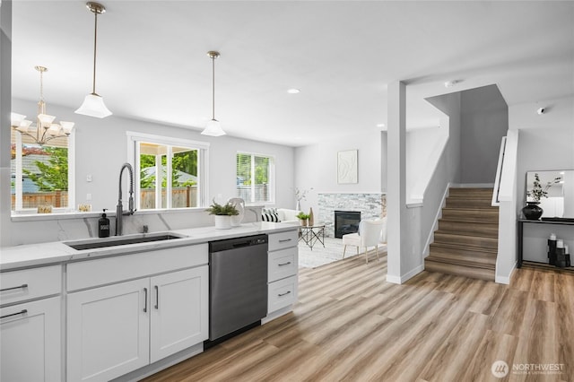 3410 102nd Ave NE, Lake Stevens, WA 98258 - kitchen featuring dishwasher, a sink, a fireplace, light wood-type flooring, and white cabinets