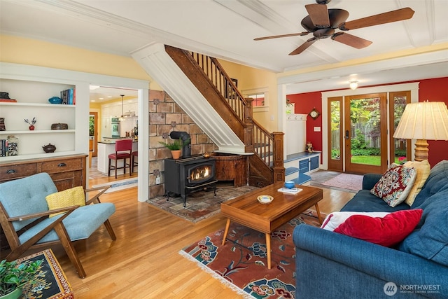 9026 SW 184th St, Vashon, WA 98070 - living area featuring light wood finished floors, a wood stove, stairs, a ceiling fan, and crown molding