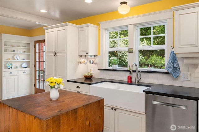 9026 SW 184th St, Vashon, WA 98070 - kitchen with stainless steel dishwasher, dark countertops, white cabinets, plenty of natural light, and ornamental molding