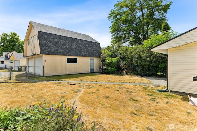 208 Barksdale Ave, Dupont, WA 98327 - view of side of property with roof with shingles, a detached garage, a gambrel roof, an outbuilding, and a gate