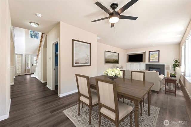 5004 98th Avenue Ct W, University Place, WA 98467 - dining room featuring dark wood finished floors, a glass covered fireplace, and a ceiling fan