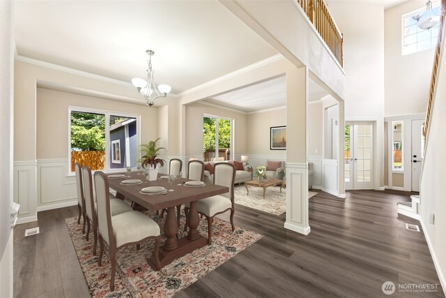 5004 98th Avenue Ct W, University Place, WA 98467 - dining space featuring a chandelier, a decorative wall, wainscoting, dark wood-type flooring, and ornamental molding