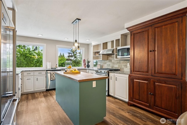 7650 SE Southworth Dr, Port Orchard, WA 98366 - kitchen with built in appliances, wood finished floors, range hood, tasteful backsplash, and white cabinetry