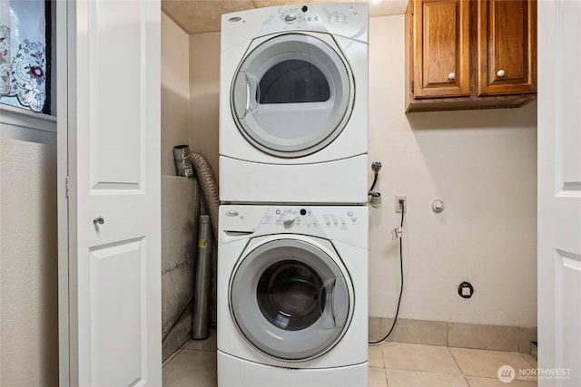 7650 SE Southworth Dr, Port Orchard, WA 98366 - laundry area with stacked washer / dryer, light tile patterned floors, and cabinet space