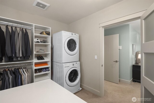 212 5th Ave W, Kirkland, WA 98033 - laundry room with stacked washer / dryer, light colored carpet, and baseboards