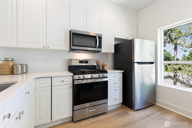 6816 NE 153rd Pl Unit D, Kenmore, WA 98028 - kitchen with appliances with stainless steel finishes, tasteful backsplash, white cabinets, and light countertops