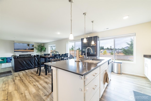 15177 Prescott Loop SE, Yelm, WA 98597 - kitchen featuring light wood-type flooring, a center island with sink, white cabinets, hanging light fixtures, and recessed lighting