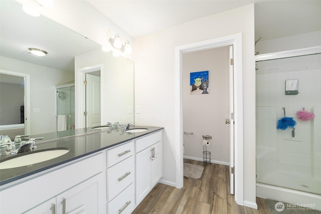 15177 Prescott Loop SE, Yelm, WA 98597 - full bathroom with a shower stall, double vanity, and wood finished floors