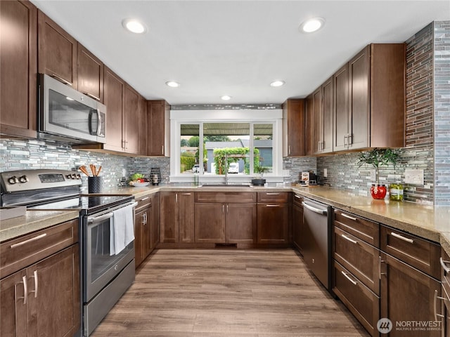 2540 N Astor Ave, East Wenatchee, WA 98801 - kitchen with stainless steel appliances, decorative backsplash, light wood-style floors, recessed lighting, and light stone countertops
