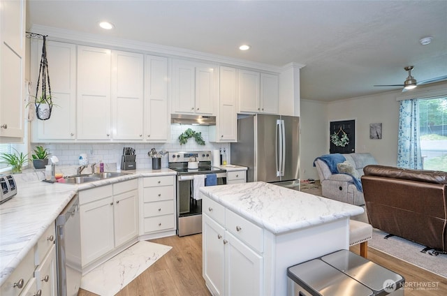 170 E Soundview Dr E, Shelton, WA 98584 - kitchen with stainless steel appliances, under cabinet range hood, open floor plan, light wood-style floors, and decorative backsplash